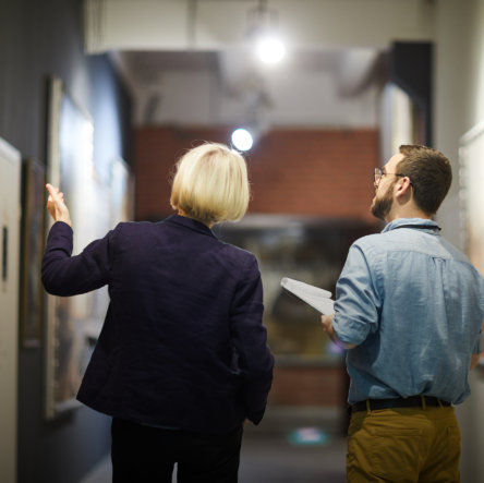 man and woman looking at the painting in art gallery