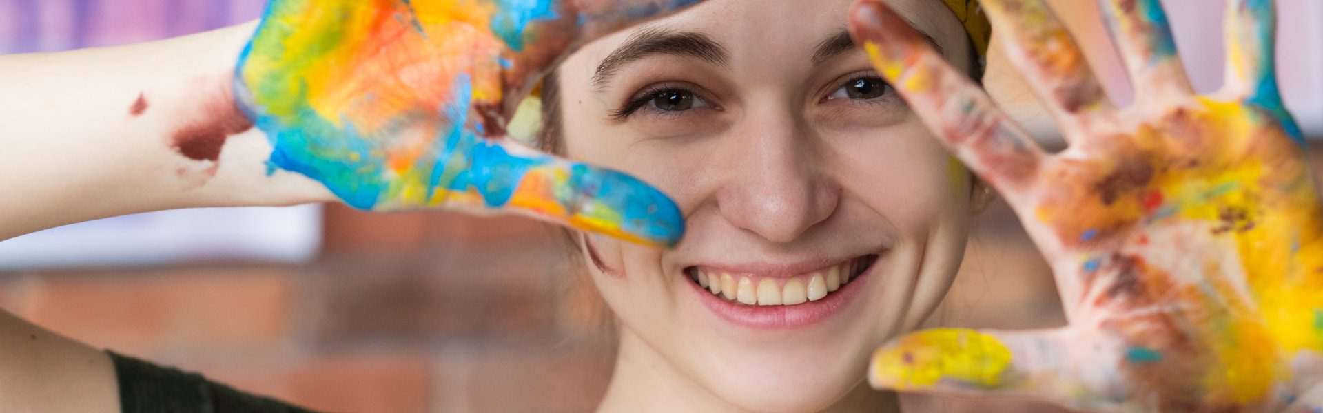 woman smiling with paints in her hand