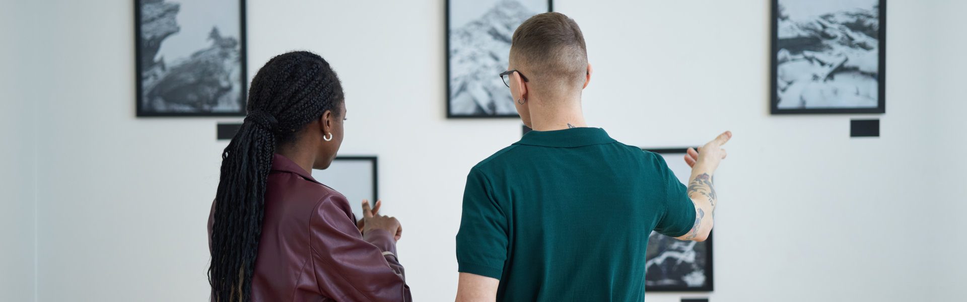 people looking at the paintings on the wall